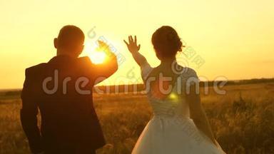 一男一女在夕阳下用手秀出一颗心。浪漫之旅中的恋人。团队合作